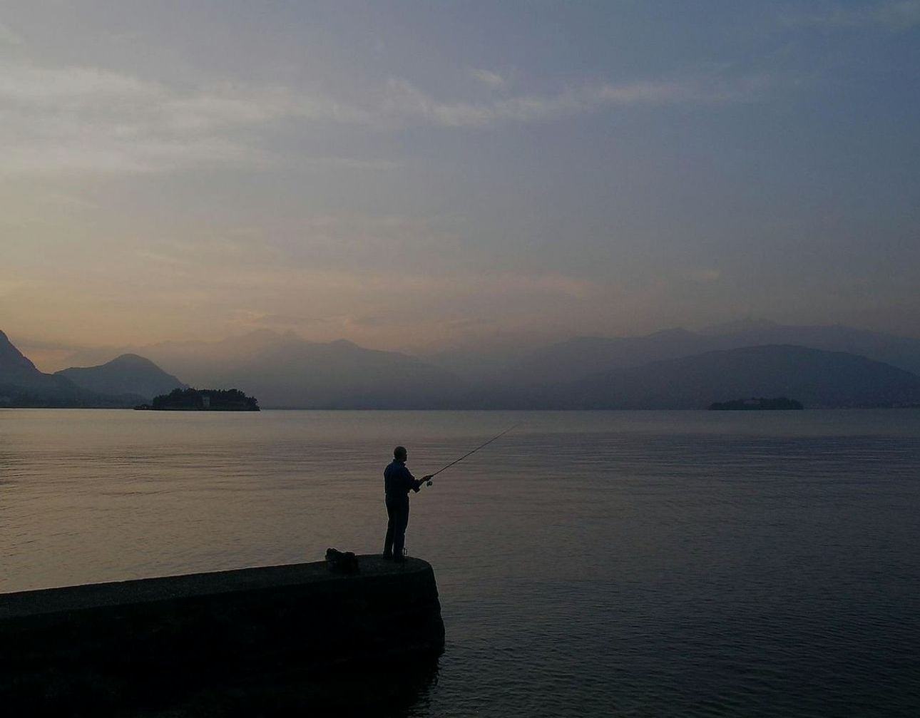 An angler checking knots and rigging by early morning light